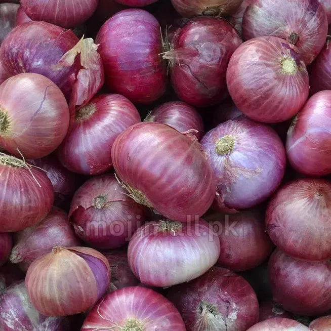 A close-up pile of red onions with purplish-red papery skins and pale off-white bulbs showing through, filling the entire frame.